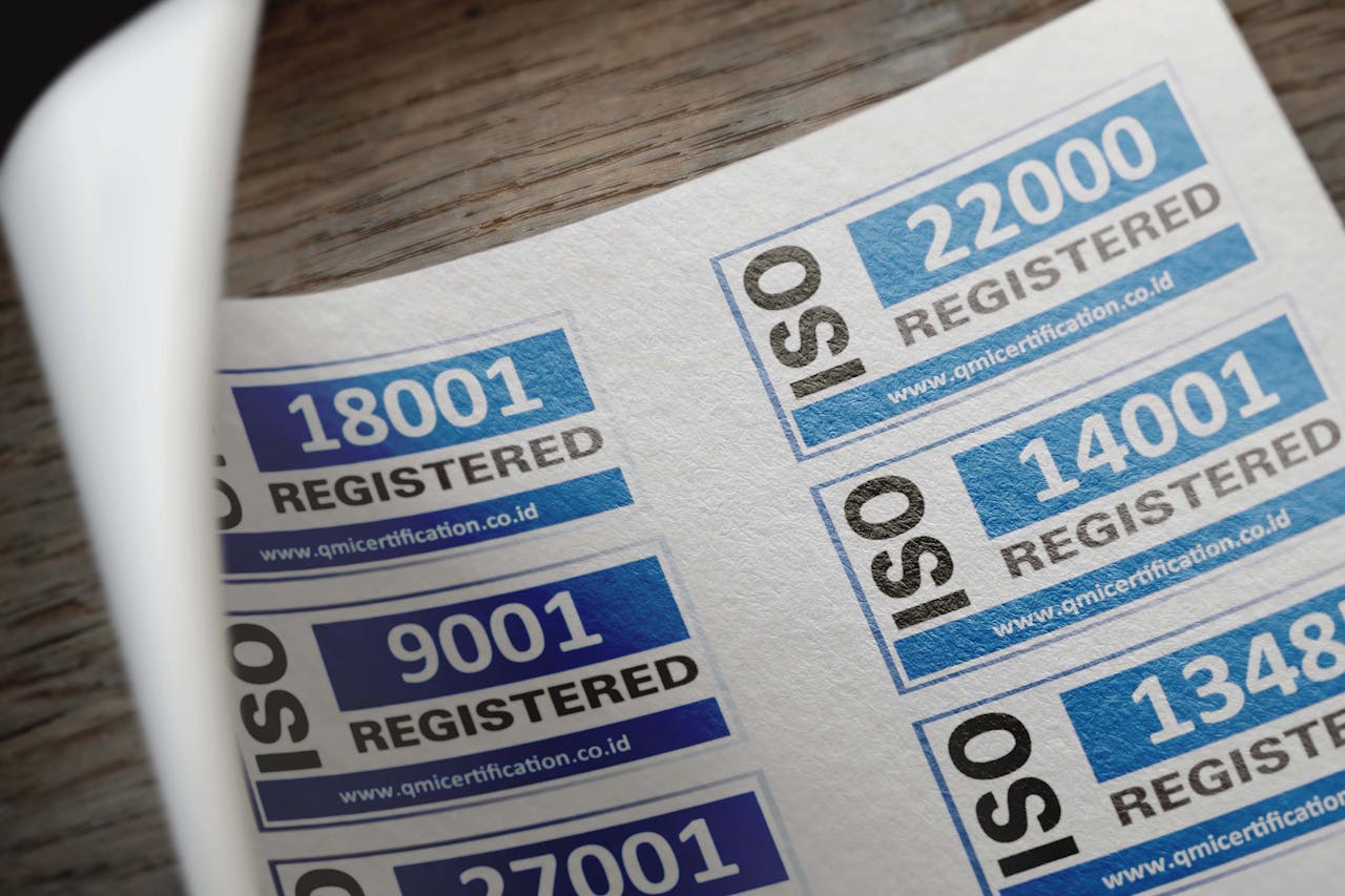 Services ISO certification stickers with registration numbers on paper.